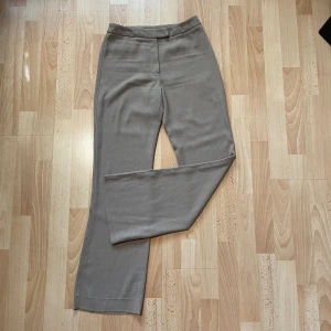 Beigea kostymbyxor  - Supersnygga kostym byxor perfekta för våren. I fint skick som nya. Lappen säger Stlk 38 men skulle nog säga S. Både knapp och dragkedja. Passar om man har lite längre ben!