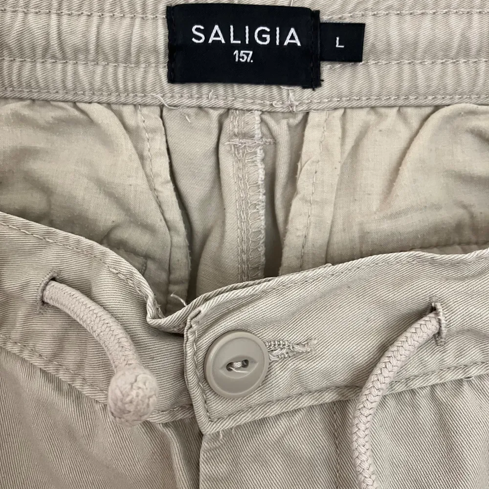 Saligia cargobyxa. 100% bomull, bekväm passform i midja med snörresor, loose passform. Sparsamt använda.. Jeans & Byxor.