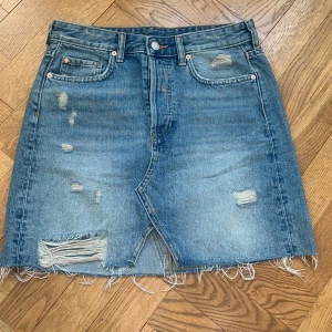 Denim Kjol hm - Super snygg denim kjol från hm med slitz fram jag lite slitna detaljer.  St 38  Använd fåtal gånger nyskick 