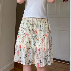 Blommig kjol 🌺 - Söt väckad kjol i beige med blommigt mönster från name it.🌸🌷🌺 Knälånga på mig som är 173cm.🤗 Står 152 som storlek men skulle säga att den passar XS-S. Använd en gång. Skriv för fler bilder😇 