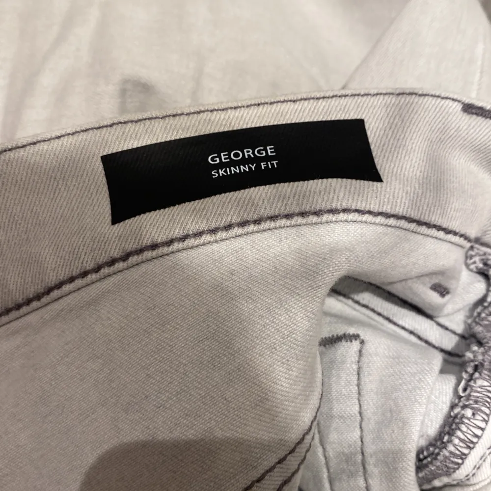 Ett par fräscha dondup jeans i modellen George. Storleken är 30 och dem är i en väldigt ljus grå färg. perfekta nu till sommaren. Det är den senaste kollektionen av George, finns en defekt inget man ser men värt att tillägga. Den är där bältet sitter. Jeans & Byxor.