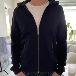 Prada Zip Hoodie - Säljer nu denna extremt snygga hoodien/vår jacka från Prada. Luvan är i tech material vilket gör den till en vårjacka. Storleken är M och färgen är mörkblå. Kvitto och påse finns kvar! Skriv till mig vid frågor eller funderingar. 