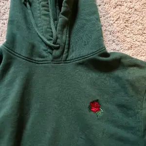 Skitstilig grön hoodie med en röd ros. Skitcool som alla älskar. Den är skitskön Används inte längre. Men älskade den