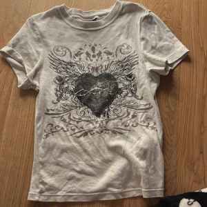 Vit tröja med snyggt print  - Köpt på h&m och är i jätte fint skick! Sitter rätt så tight.