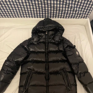 Moncler Maya - Svart - Moncler maya jacka som säljs på grund av dålig passform. Jackan köptes i andrahand och är liten i sin storlek. Har använts endast ett fåtal gånger och är i toppskick. Vid snabbköp så kan priset diskuteras!