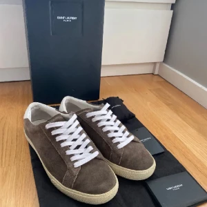 Saint Laurent sneakers  - Säljer mina Saint Laurent sl/06 i en mycket snygg färg. Skorna görs inte längre. Skicket är 9/10, väldigt lite använda. Nypris ca 7000kr. Storleken är 41,5 men sitter lite större. Hör av dig vid frågor. Öppen för prisförslag.