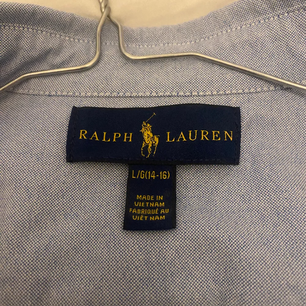 Klassisk Ralph Lauren skjorta i färgen blå. Storleken är 14-16 eller L (barnstorlek). Super stilig och passar alla!. Skjortor.
