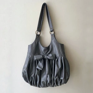 ROSETTVÄSKA🎀 Grå väska - Supersöt grå vintage rosettväska jag köpt second hand.🎀✨💝 Väskan är andvänd men är i bra skick förutom en liten innerficka (se bild 3) där tyget gått upp lite. Lätt att sy igen om man vill.💝 Skriv i chatten för fler bilder så löser jag det.😊 