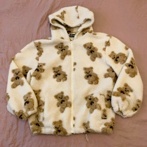 Sherpajacka med teddybjörnar - Assnygg sherpajacket från Aelfric Eden. Använd endast enstaka gånger så ser ut som ny. Är en S men är stor i storleken, finns band vid midjan som går att dra åt