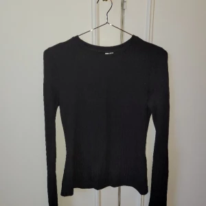 Svart ribbad tröja med dragkedjor - Svart ribbad tröja med dragkedjorpå ärmarna. Från Nelly.