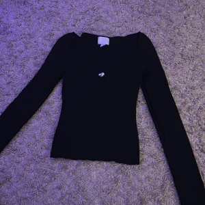 Svart tröja med sten - En svart basic tröja med en vit sten. Inte mycket använd och i väldigt fint skick.