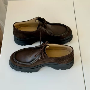 Chunky läder loafers - Läderskor med rundad tå från Arket i 100% premiumläder. Made in portugal. Riktigt bra kvalitet. Nypris 1890kr I nyskick. Endast använda 1 gång pga för stora för mig. Suede / mocka på sidorna. Bruna Läderboots / seglarskor / chunky loafers / lågskor 