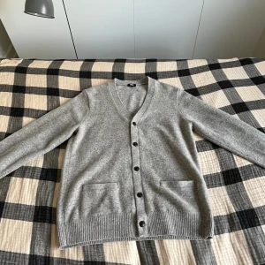 Grå ull cardigan/kofta - Nu säljs denna kofta/cardigan i ull ifrån märket uniqlo. Tröjan är luftig och passar perfekt till sommaren! Den är helt i nyskick utan några defekter. Det står small på tröjan med den är stor och sitter som medium. Frågor eller funderingar i DMs! 🍾