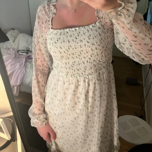Blommig klänning  - Säljer min vita sommar klänning med gröna blommor då det inte är min stil längre, använd ett fåtal gånger💕skriv vid intresse eller för mer information 
