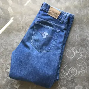 Jeans i grovt material av history iceberg, broderat motiv på bakfickan och väldigt bra kvalitet. Tåliga lite påsiga jeans.
