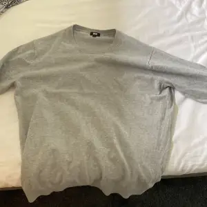 En grå sweatshirt i storlek L från Uniqlo som jag aldrig använt, inga defekter och snygga detaljer vid ärmarna