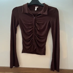 Oanvänd brun topp  - Helt ny oanvänd brun topp från Nellys egna märke. Den är i storlek xxs men är stretchig i materialet. 