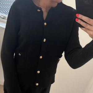 Zara stickad kofta - Stickad kofta från Zara med gulddetaljer. Använd 1 gång så i helt nyskick. 