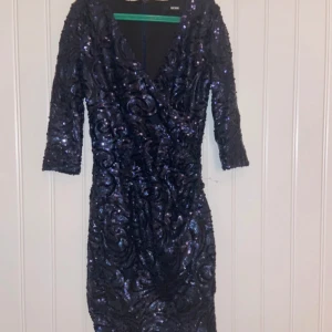 Klänning - Klänning med paljetter och mönster. Ganska kort. V-ringad❣️