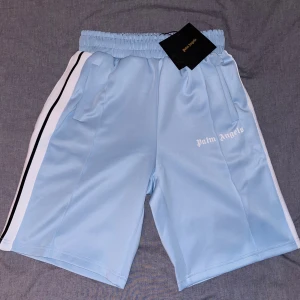 Palm Angels shorts - Baby blue - Säljer ett par skitsnygga Palm Angels shorts som passar perfekt till sommaren. De har inte använts på grund av storlek. Skick 10/10. M passar också L och har en ”längre” benlängd. Skriv jätte gärna vid frågor. 