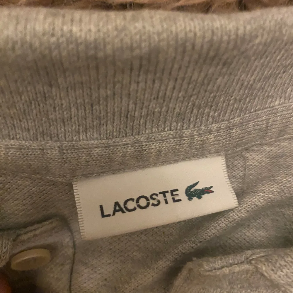 Säljer Lacoste piké grå t shirt. Har bara  prova på den. Storlek XS helt ny har paketet och allting. Säljer pgv för liten. . T-shirts.