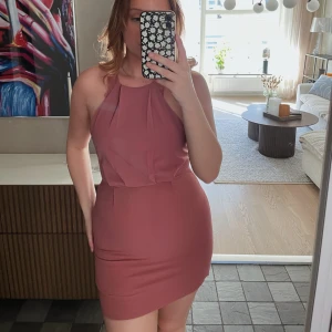 Rosa klänning med öppen rygg - Säljer denna jättefina rosa klänning med öppen rygg. Från Nelly, storlek 34. Endast använd ett fåtal gånger 