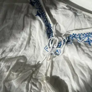 Sjukt fin sommarblus/tröja i vitt genomskinligt tyg med blåa detaljer! Storleken är bortklippt, men den passar M-L! Först till kvarn!