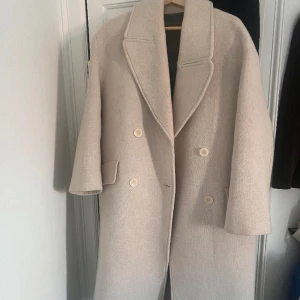 Beige/vit kappa - Beige/vit kappa från zara i deras premium kollektion, använd en gång, nysick! Köpte L för ville ha den lite oversized, så passar för den som är en S eller XS också!