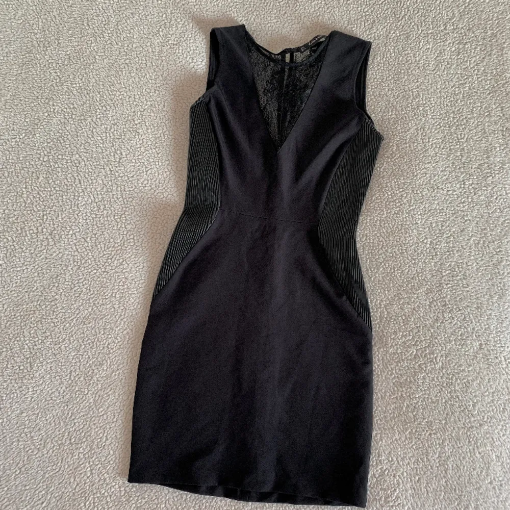 Otroligt snygg svart mini klänning från ZARA med ribbade detaljer på sidorna av revbenen och spets i ryggen. Figursydd passform och väldigt stilig. Aldrig använd, ny utan anmärkningar.. Klänningar.