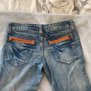 Replay Jeans - Skit snygga replay jeans med orange detaljer. Lowwaist