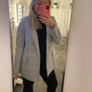 Kort kappa - Skitcool kavaj/kappa i ett rutigt mönster från HM!! Den är i storlek 36 men skulle säga att den passar perfekt till 34 med! Perfekt nu till våren! Den är grå/blå och vit i mönstret!