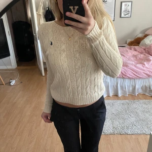 RALPH LAUREN STICKAD - Säljer denna supersnygga stickade tröjan från POLO RALPH LAUREN! Den är köpt secund hand och är i väldigt fint skick! Jättesöt beige färg!  