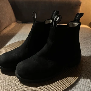 Sheperd skor - Shepherd | Sanna Outdoor Black Shepherd Är ett par chelseaboots i läder med insida i varm och skön fårskinn. Bootsen har en bred resår i sidorna utav skaftet och vävda hällor. Yttersula i gummi och klackhöjd 3 cm. Frakt tillkommer. Nypris 1200:-