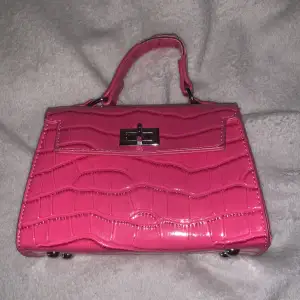 Liten gullig ”skrik” rosa väska. Använd men ser ut som ny. Förut på ”handtaget”. 