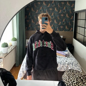 Svart hoodie från Sweet SKTBS - En svart hoodie från Sweet SKTBS med ett färgglatt tryck i rött, vitt och grönt på bröstet. Hoodien är i storlek M och kostar 699kr nypris 
