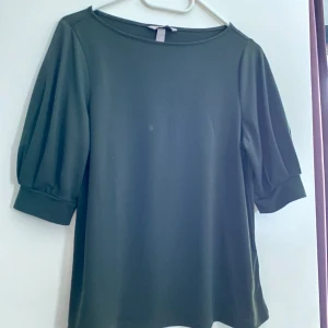 Topp med ballongärm - Topp med ballongärm och ledig passform. Strl S. Fint skick! Fläcken på första bilden är från kameran och inte på tröjan.   Modellen på bild 3 har vanligtvis strl XS, och modellen på bild 4 har vanligtvis strl M, som preferens.