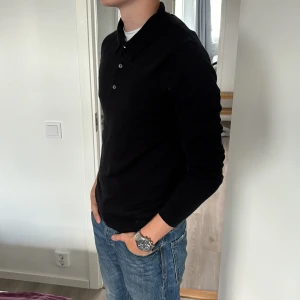 Svart långärmad piké  - Säljer nu min feta långärmade piké. Orginal pris 1400kr mitt pris 350kr. Tröjan är knappt använd och är i ett mycket bra skick.