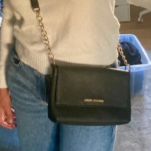 Äkta Michael Kors svart axelremsväska  - Äkta Michael Kors svart axelremsväska. Guldiga detaljer.