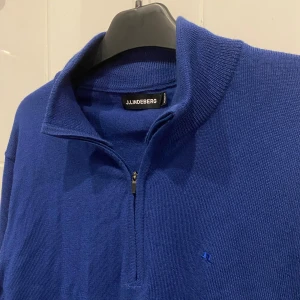 J.Lindeberg Halfzip - Blå stickad halfzip från J.Lindeberg, storlek M. Skick som ny! Nypris runt 1500.