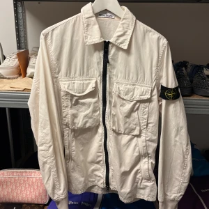 Stone Island Overshirt- Bone White - WTS Stone Island Overshirt- Bone White Storlek: Medium Skick: 7/10, se lagningar Pris: 2500:-    Vänligen hör av dig vid frågor eller önskemål om mer bilder osv.