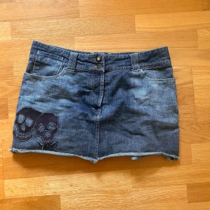 Jeans kjol med detaljer - 46 cm rakt över midjan 33 cm längd coola skelett på framsidan och volanger på baksidan