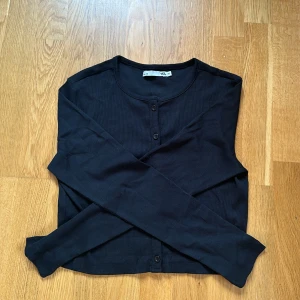 En svart kortade knapp tröja från Lager157 - Den är kort på och kommer aldrig till användning därför säljer jag den. Den är även helt ny. Pris kan diskuteras.