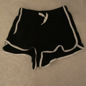 Svarta mjukis shorts - Svart mjukisshorts med lite vita detaljer. Bara testad men aldrig använd. Säljer pga de börjar bli för små. 