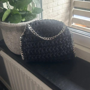 Svart stickad stella väska - En fin svart stickad handväska med silverkedjedetaljer. Väskan har en avtagbar kedja som kan användas som axelrem🤗använd i ca en månad men har inga defekter kedjan är inte rostig eller likande, köpte nypris 800🥰