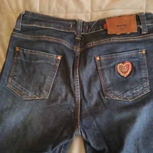 Moschino jeans - Säljer ett par dö snygga jeans som tyvärr inte passar mig(därefter kommer jag inte skicka några bilder med dem på). Jeansen är raka och skulle säga midwaist. Midjemått rakt över:36cm. Inrebenslängd:70cm+3cm upsytt som går att sprätta❤️