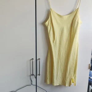 Gul sommarklänning - Kortklänning i med slits. Materialet påminner om linne. Från Asos, storlek 34. Perfekt strandklänning 