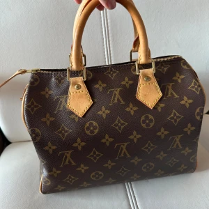 Handväska  - Säljer en äkta Louis Vuitton speedy 25🤎 DC:SD3037  Mått: bredd 25 cm, höjd 19cm, djupt 14 cm Det finns revor på konterna inga hinder vid användning, inuti av väska topp i skick, komplett med stickade handtag och väskorganisator , fråga flera bilden, 