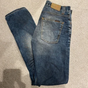 Nudie Jeans grim tim - Säljer ett par Nudie Jeans i modellen grim tim. Storleken är 32/34 och färgen är ”used blackcoated”. Säljer då de tyvärr är aningen långa på mig, är 182.
