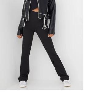 Byxor - Svarta Byxor i typ kostym material från Nelly, använda vid 1 tillfälle, i ny skick storlek s