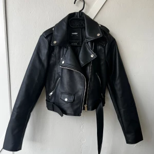 Skinnjacka med skärp - Jacka i skinnimitation, använd en gång men är tyvärr för liten för mig. Supersnygg, perfekt till våren Storlek S, passar bäst en liten S eller XS